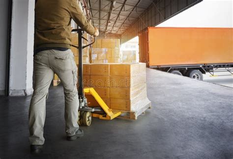 Workers Unloading Packaging Boxes On Pallets Into The Cargo Container Trucks Loading Dock