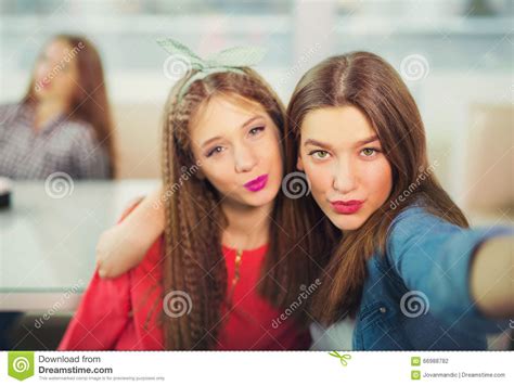 Two Girls Pouting While Taking A Selfie Photo On Mobile Phone Stock