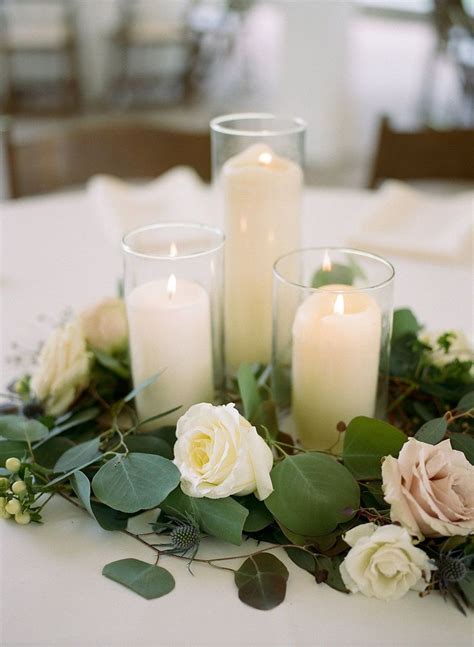 Pillar Candles Surrounded With Gorgeous Flowers And Greenery