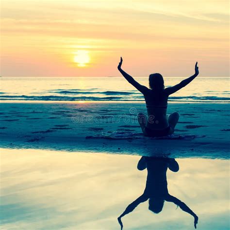 Silueta De Una Mujer Joven Que Se Sienta En La Playa Durante Una Puesta Del Sol Hermosa Imagen