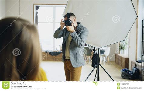 Professional Photographer Taking Photos Of Model On Digital Camera
