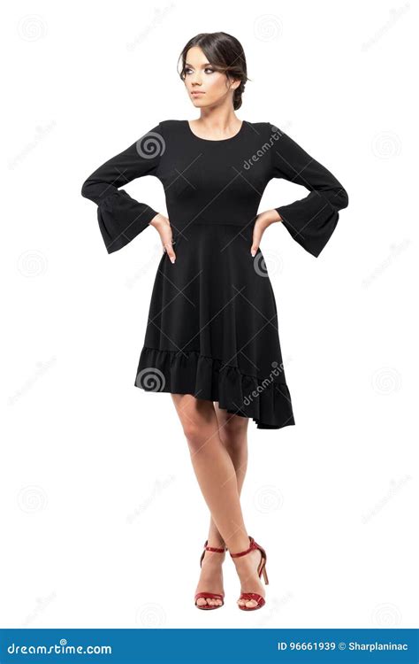 Serious Hispanic Woman In Black Flounce Dress With Hands On Hips