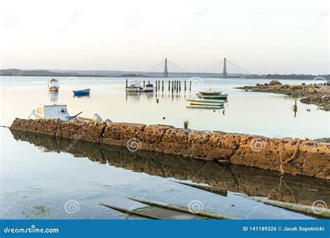 Boats And Bridge Over Guadiana River Which Is A Border Between Spain