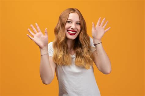 Positive Young Brunette Woman Smiling Happily And Spreads Her Hands To