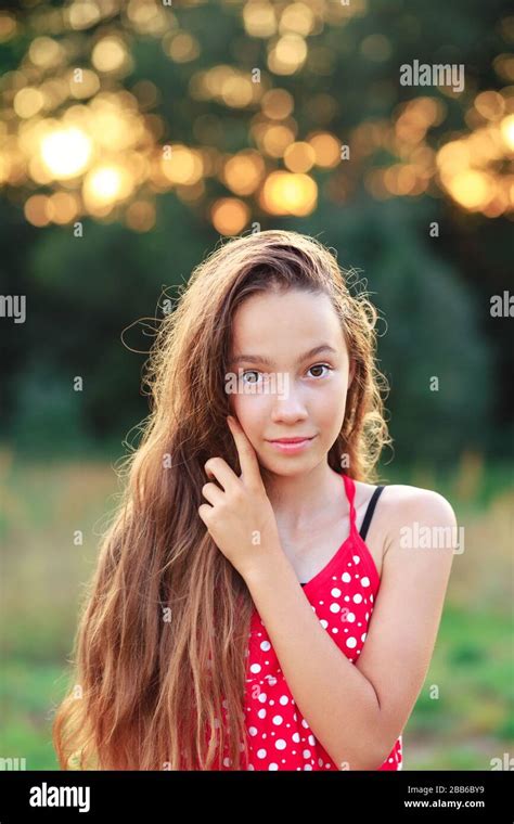 das schöne teen girl lächelt und genießt die natur im park bei sonnenuntergang stockfotografie