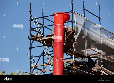 Plastic Rubbish Chute Attached To Scaffolding On House Extension In