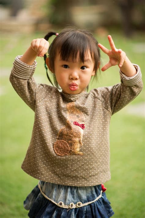 5 Year Old Chinese Asian Girl in a Garden Making Faces Stock Image ...