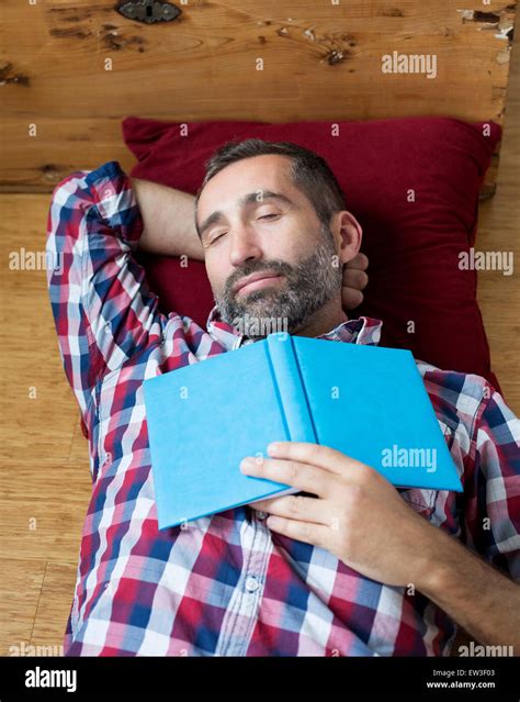 Man Sleeping And Holding A Book Stock Photo Alamy