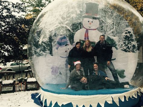 A Group Of People Posing In Front Of A Snow Globe
