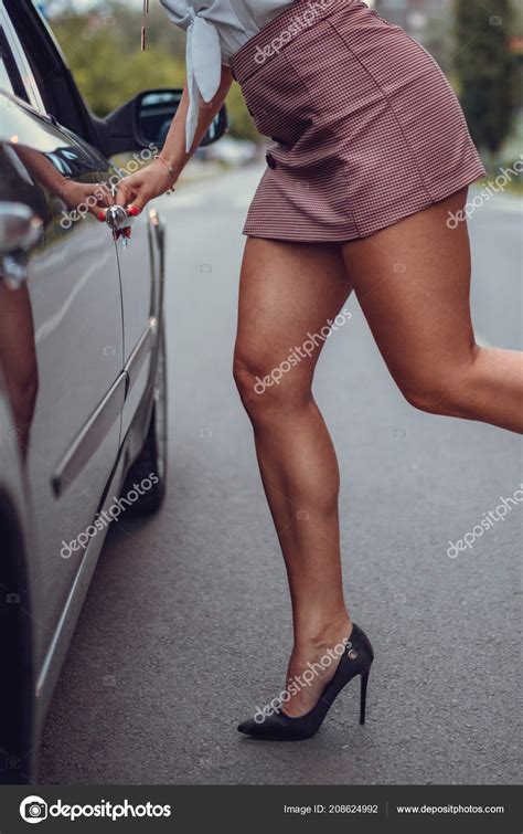 mulher com uma saia curta entrando carro close — fotografias de stock © milanmarkovic 208624992