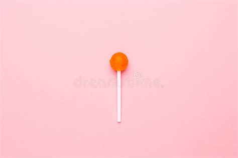 Sweet Orange Candy Lolipop On Pastel Pink Background Minimalist