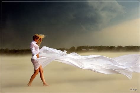 Woman On Beach White Flowing Fabric Windy Ominous Looking Sky All