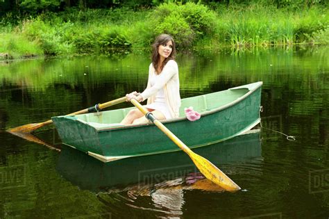 Caucasian Woman Rowing Boat In Pond Stock Photo Dissolve