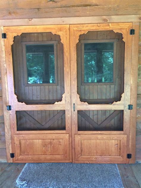 Two Wooden Doors Are Open On The Inside Of A Cabin With Wood Walls And