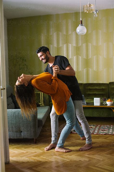 Couple Having Fun Dancing In The Apartment By Stocksy Contributor Mosuno Stocksy