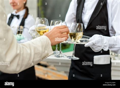 Midsection Of Professional Waiter In Uniform Serving Wine During Buffet