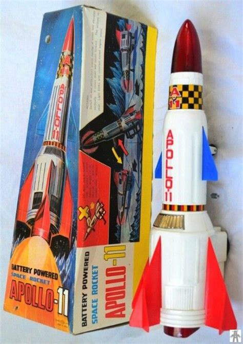 A Red And White Toy Rocket Sitting On Top Of A Box Next To Its Packaging