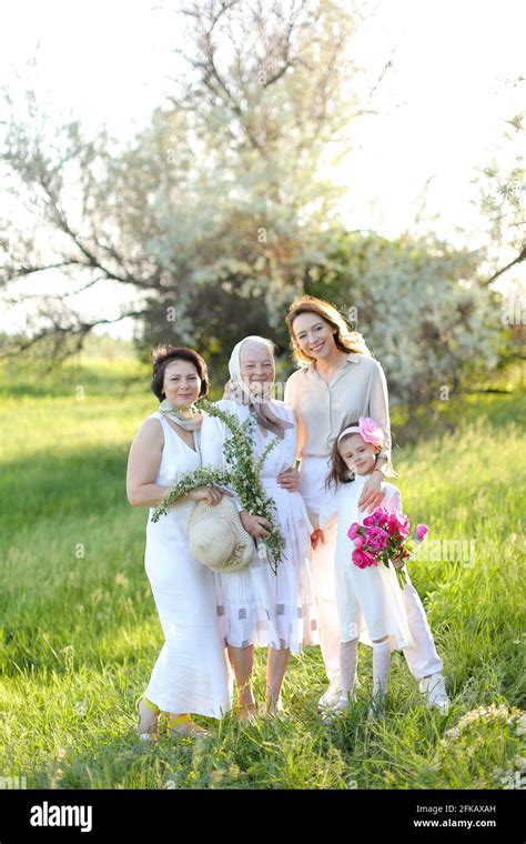 Caucasian Granny In White Dress With Daughter And Granddaughters