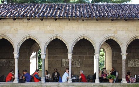 A Group Of People Dine In A Cafe Situated In A Stone Medieval Cloister