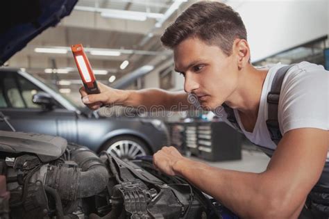 Young Handsome Car Mechanic Repairing Vehicle In His Garage Stock Image