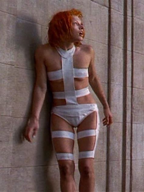 A Woman With Red Hair And Bandaged Body Standing In Front Of A Wall