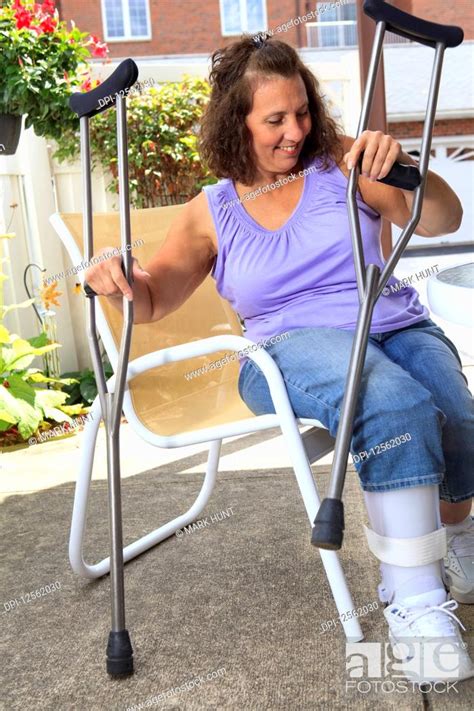 Woman With Spina Bifida Getting Up With Crutches Stock Photo Picture