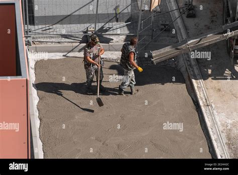 Group Of Builders Working Together On Pouring Cement During An Upgrade