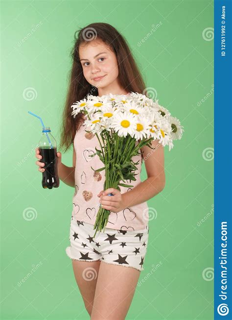belle jeune fille se tenant en kola de mains dans la bouteille et le bouquet de la camomille