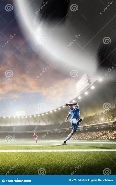 Soccer Players In Action On Sunset Stadium Background Stock Photo