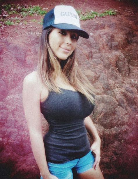 A Woman In Shorts And A Hat Posing For A Photo