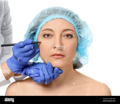 Plastic Surgeon Applying Marks On Woman S Face Against White Background Stock Photo Alamy