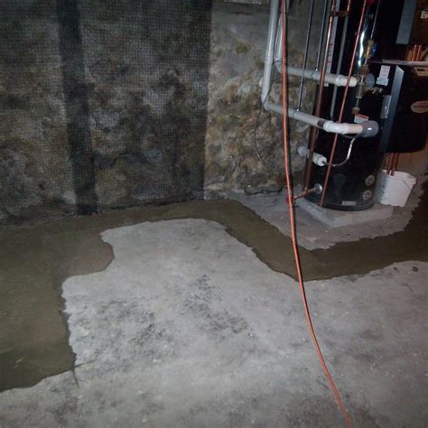 A catch bowl, drainpipe and plumbing trap lie beneath. Basement Perimeter Drain Cover • BASEMENT