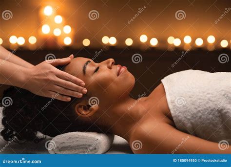 Peaceful Black Woman Getting Head Massage At Luxury Spa Stock Photo