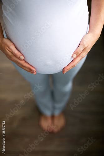 Looking Down Image Of Pregnant Woman With Belly Button Poking Out