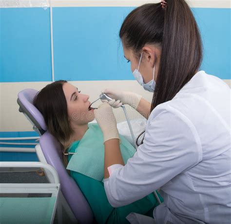 Young Woman Visiting Dentist In Stomatological Clinic Doctor Examines