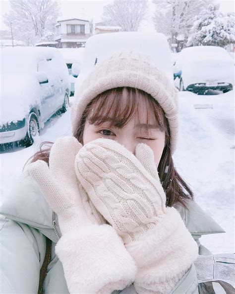A Young Woman Covers Her Face With Gloves While Standing In Front Of