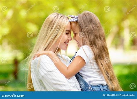 Cute Mother And Little Daughter Hugging Smiling Each Other Outside