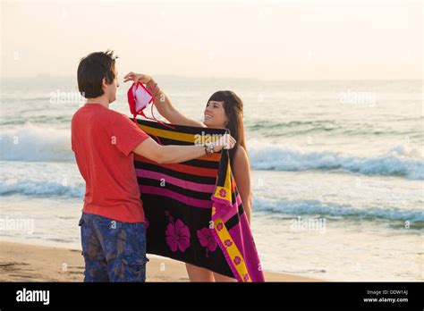 Girl Changing Clothes On The Beach And Teasing Her Boyfriend Stock Photo Alamy