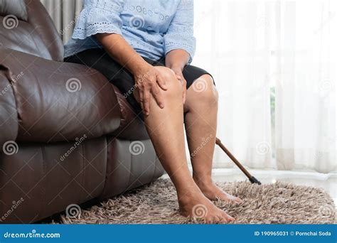 Senior Woman Suffering From Knee Pain At Home Health Problem Concept