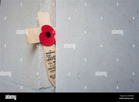 An Artificial Poppy On A Cross Stands In Front Of Inscriptions With The
