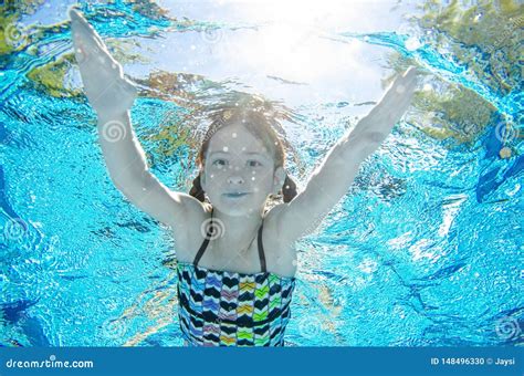 Child Swims Underwater In Swimming Pool Happy Active Teenager Girl