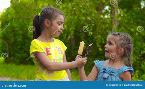 two girls eating popsicle ice cream in park stock footage video of adorable dress 130020440