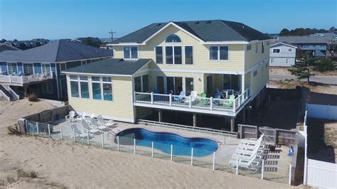 An Aerial View Of A Beach House With A Swimming Pool In The Foreground