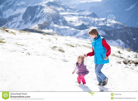 Two Children Playing In Snow In Mountains Stock Photo