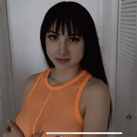 A Woman With Long Black Hair Wearing An Orange Top