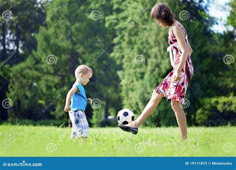 Madre E Hijo Que Juegan La Bola En El Parque Imagen De Archivo