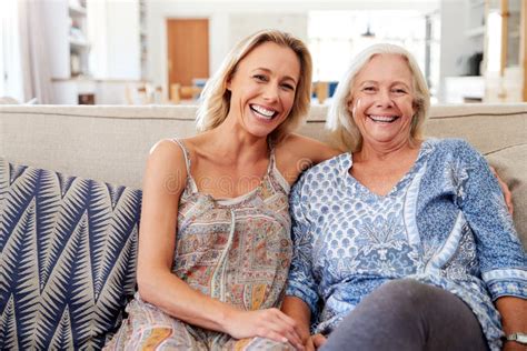 Portrait Of Smiling Mother With Adult Daughter Relaxing On Sofa At Home Stock Image Image Of