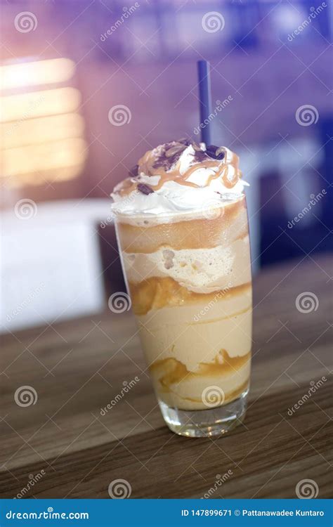 A Tall Glass Of Iced Frappe With Whipped Cream And Caramel Syrup With