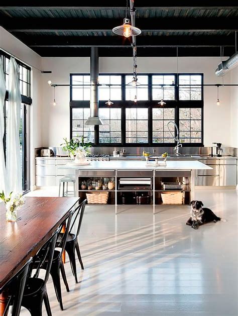 Windows and door panels reaching for the 12 foot ceilings flood this kitchen with natural light. Decoración de estilo industrial: 10 claves para acertar