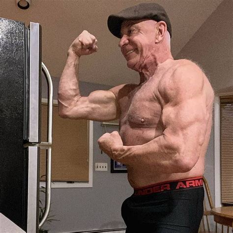 An Older Man Flexing His Muscles In Front Of The Refrigerator